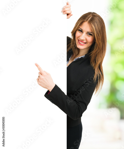 Photo: Business woman pointing her finger to a white board Business woman pointing her finger to a white board