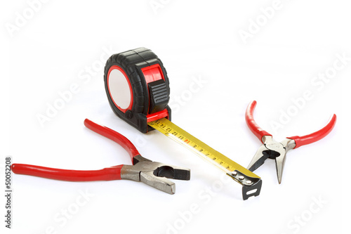 Photo: red pliers and measuring tape isolated on white red pliers and measuring tape isolated on white