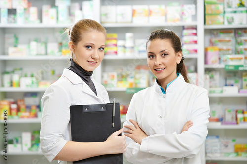 Photo: Two Pharmacy chemist women in drugstore Two Pharmacy chemist women in drugstore