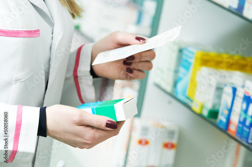 Photo: Pharmacist hands with drug and prescription Pharmacist hands with drug and prescription