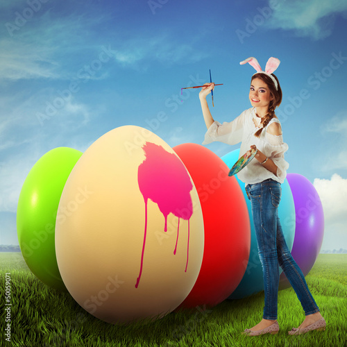 Photo: Woman coloring easter eggs on a field Woman coloring easter eggs on a field