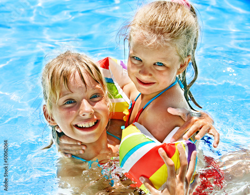 Photo: Kids with armbands in swimming pool. Kids with armbands in swimming pool.