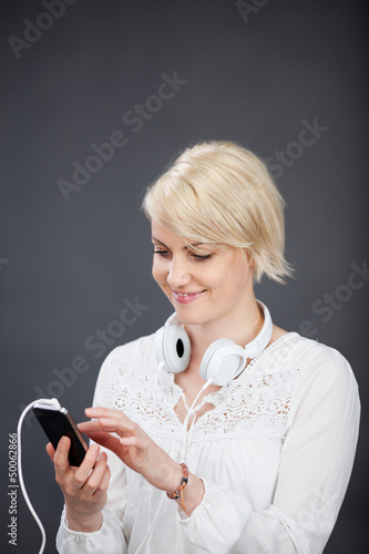 Photo: frau hört musik mit ihrem handy frau hört musik mit ihrem handy
