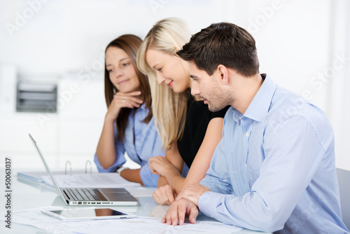 Photo: team im büro schaut auf laptop team im büro schaut auf laptop