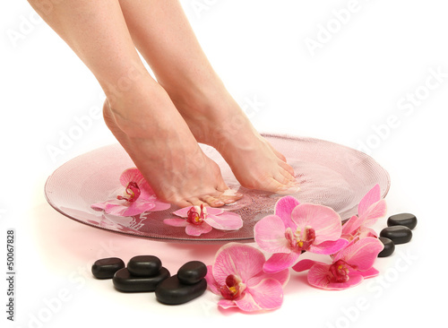 Photo: Female feet in spa bowl with water, isolated on white Female feet in spa bowl with water, isolated on white