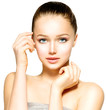Beautiful Young Woman with Fresh Clean Skin touching her Face
