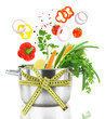 Fresh vegetables falling into a casserole pot 