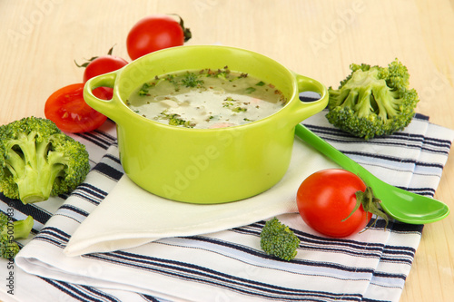Photo: Diet soup with vegetables in pan on wooden table close-up Diet soup with vegetables in pan on wooden table close-up