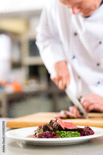 Photo: Chef in restaurant kitchen preparing food Chef in restaurant kitchen preparing food