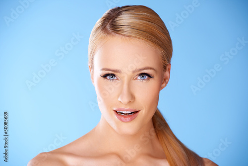 Photo: Close up portrait of blond woman on blue Close up portrait of blond woman on blue
