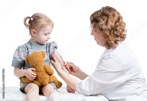Photo: doctor vaccinating kid isolated on a white doctor vaccinating kid isolated on a white