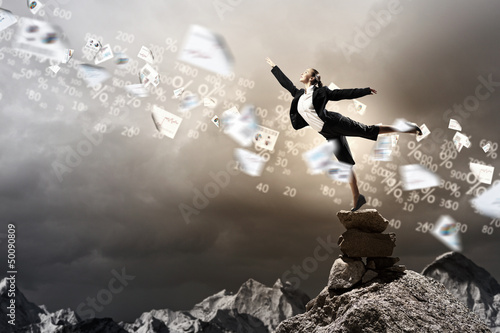 Photo: businesswoman standing atop of mountain businesswoman standing atop of mountain