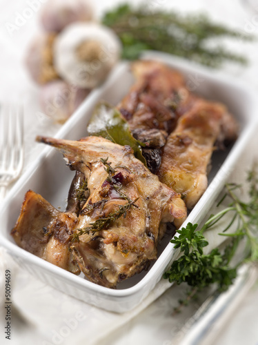 Photo: roasted rabbit with herbs and garlic, selective focus roasted rabbit with herbs and garlic, selective focus