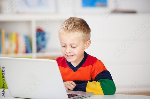 Photo: kleiner junge schaut auf laptop kleiner junge schaut auf laptop