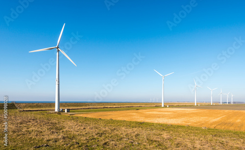 Photo: Row of modern wind turbines in a rural landscape Row of modern wind turbines in a rural landscape