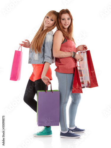 Photo: Two girls with shopping bags. Isolated over white background. Two girls with shopping bags. Isolated over white background.