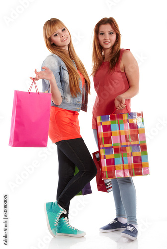 Photo: Two girls with shopping bags. Isolated over white background. Two girls with shopping bags. Isolated over white background.