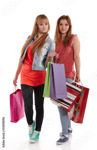 Photo: Two girls with shopping bags. Isolated over white background. Two girls with shopping bags. Isolated over white background.
