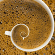 White mug full of coffee with foam in a swirl