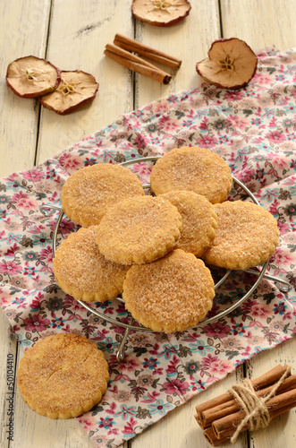 Photo: Apple cookies powdered with sugar and cinnamon on wooden backgro Apple cookies powdered with sugar and cinnamon on wooden backgro