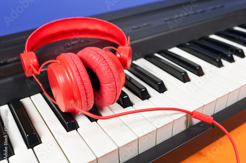 Photo: Casque rouge posé sur un piano électronique Casque rouge posé sur un piano électronique
