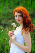 Photo: Young redhead female with dandelions. Young redhead female with dandelions.