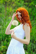 Photo: Young redhead female with big dandelion. Young redhead female with big dandelion.