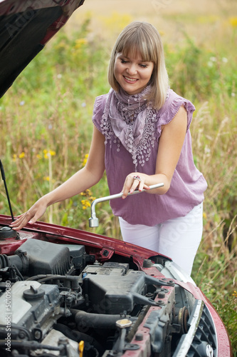 Photo: woman trying to fix the car woman trying to fix the car