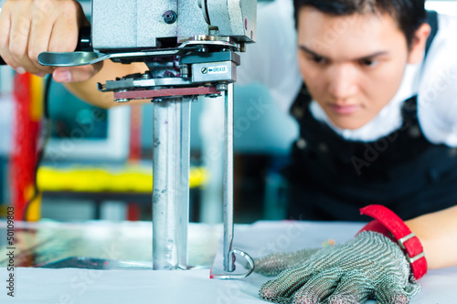 Photo: Worker using a machine in chinese factory Worker using a machine in chinese factory