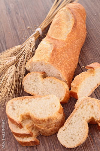 Photo: baguette and sliced on wood background baguette and sliced on wood background