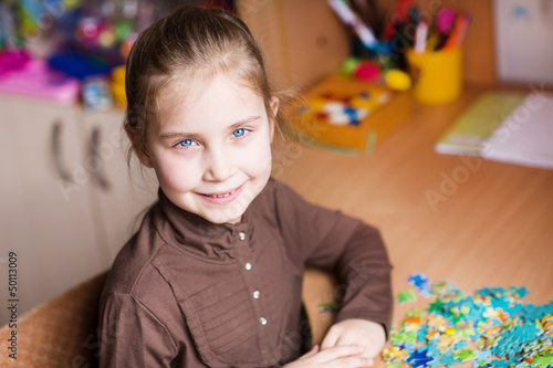 Photo: Cute little girl solving puzzles Cute little girl solving puzzles