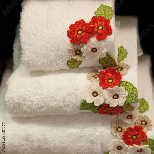 Photo: white, clean towel decorated by flowers white, clean towel decorated by flowers
