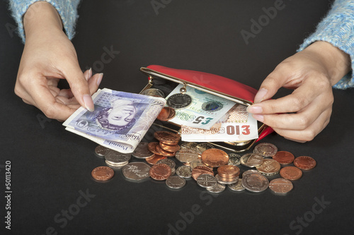 Photo: Woman's hands with Stirling currency and a red purse Woman's hands with Stirling currency and a red purse