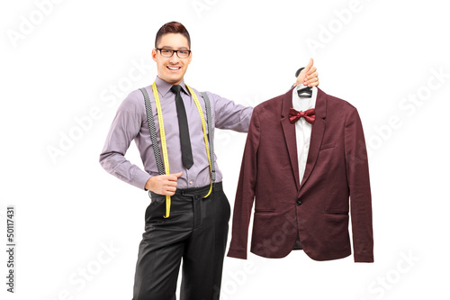 Photo: Male fashion designer holding a suit on a hanger Male fashion designer holding a suit on a hanger