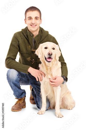 Photo: Smiling young man posing with a retriever dog Smiling young man posing with a retriever dog