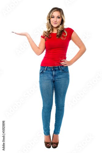 Photo: Young girl in trendy wear presenting something Young girl in trendy wear presenting something