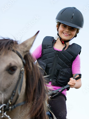 Photo: Horse riding - portrait of lovely equestrian on a horse Horse riding - portrait of lovely equestrian on a horse