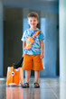 Cute little boy with orange suitcase