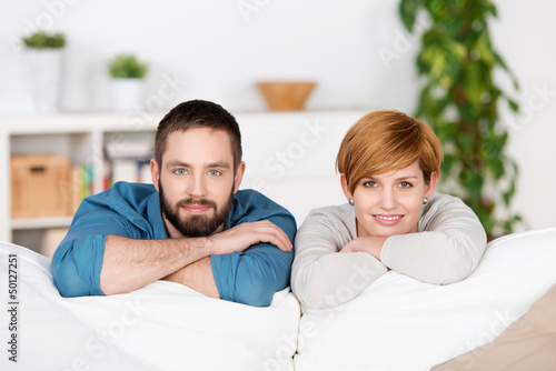 Photo: junges paar lehnt sich auf sofa junges paar lehnt sich auf sofa