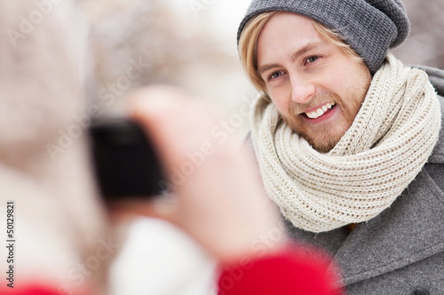 Photo: Woman taking photo of young man Woman taking photo of young man