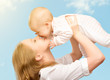 happy family. Mother kissing baby in the sky