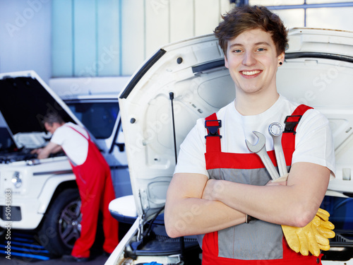 Photo: Apprentices for car mechanic is satisfied with his job Apprentices for car mechanic is satisfied with his job