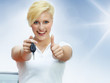 Foto: Pretty blonde woman proudly presents the key of her new car Pretty blonde woman proudly presents the key of her new car