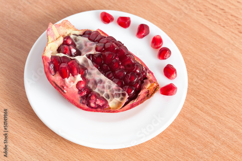 Photo: The cut pomegranate and grains on a plate The cut pomegranate and grains on a plate