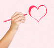 Hand with red pencil painting a heart
