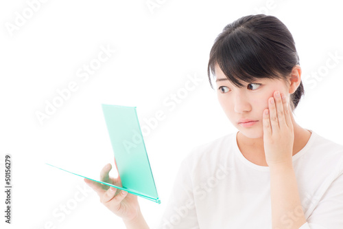 Photo: a young asian woman making up a young asian woman making up