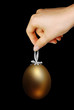 Female hand holding a golden egg