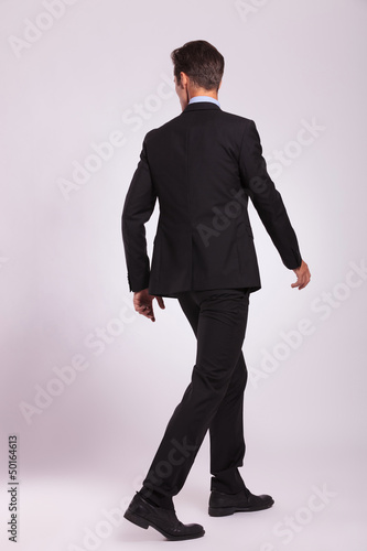 Photo: back view of business man walking back view of business man walking