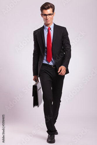 Photo: man with glasses walking with briefcase man with glasses walking with briefcase