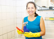  mature woman cleans bathroom